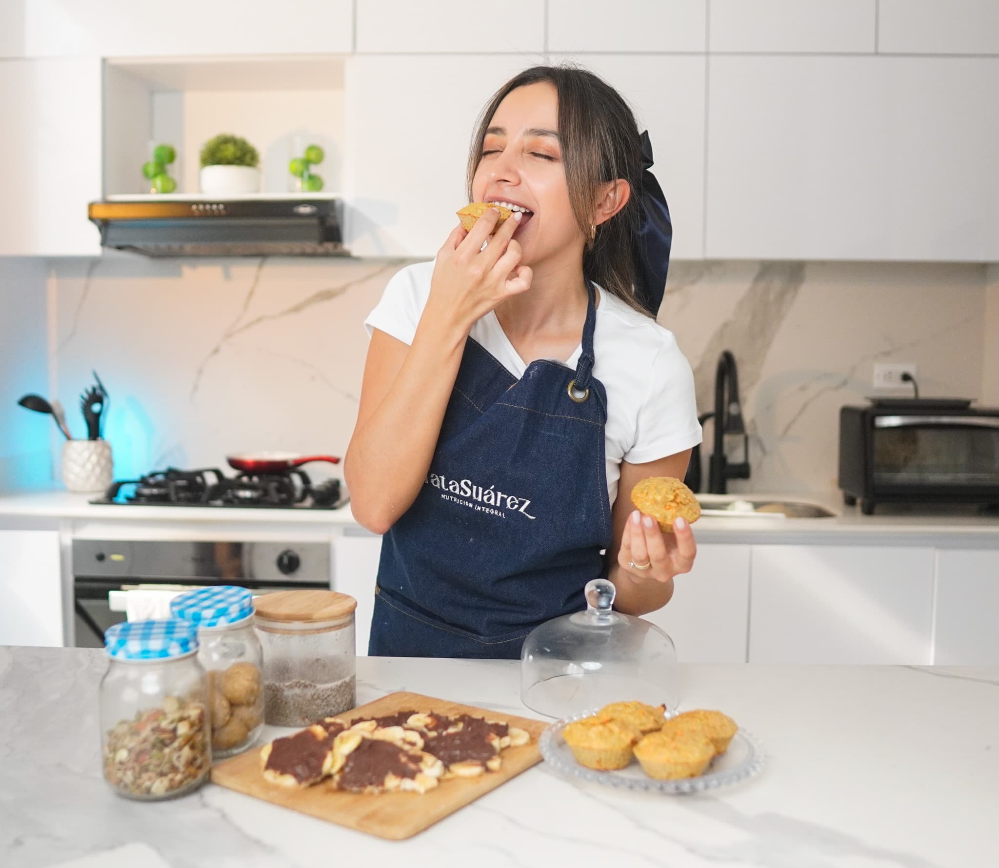 A first bite of a fresh muffin in a bright kitchen