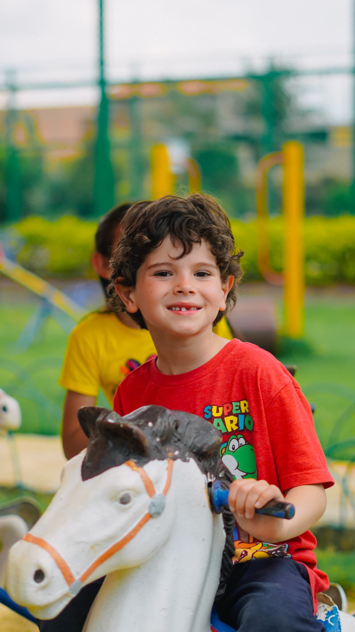 A boy riding a painted horse on the playground