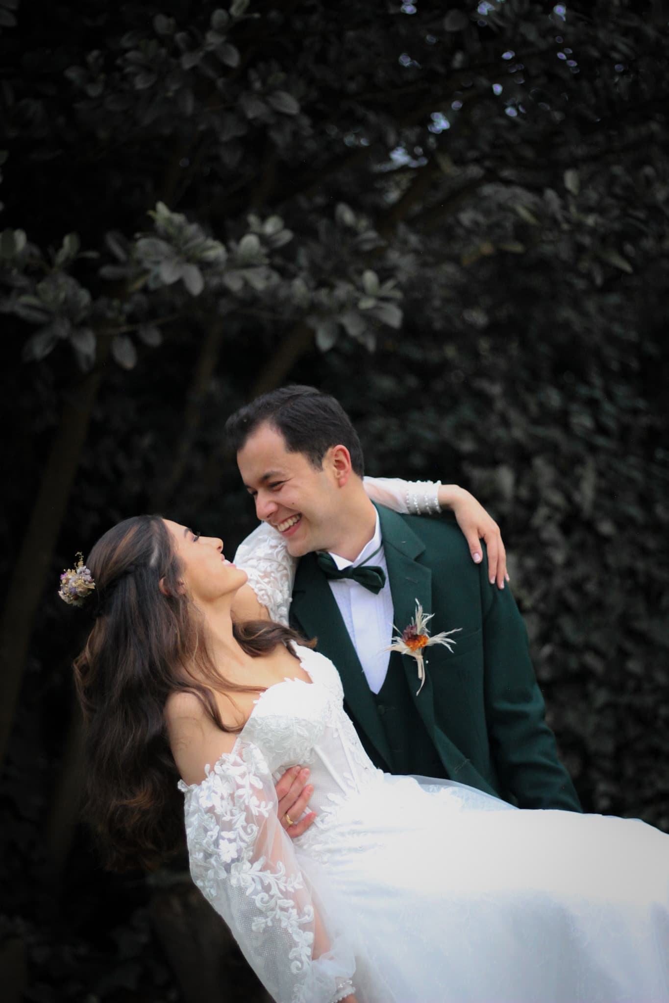 The groom dips the bride mid-laugh in the garden