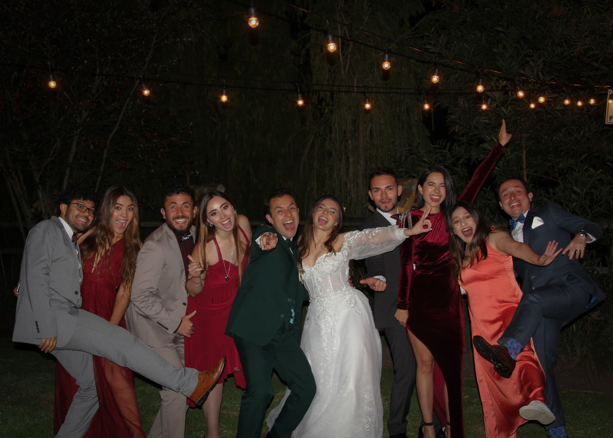 The wedding party under string lights