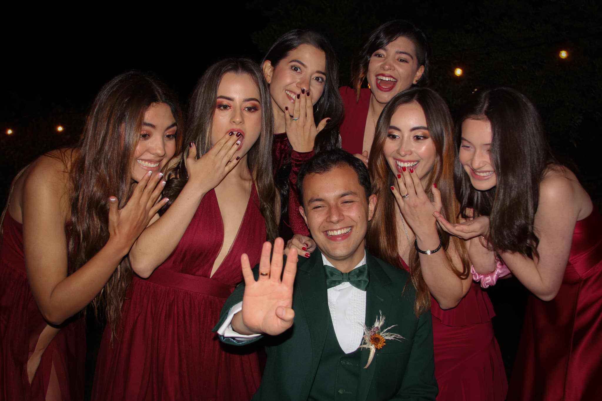 The groom shows his ring to the wedding party