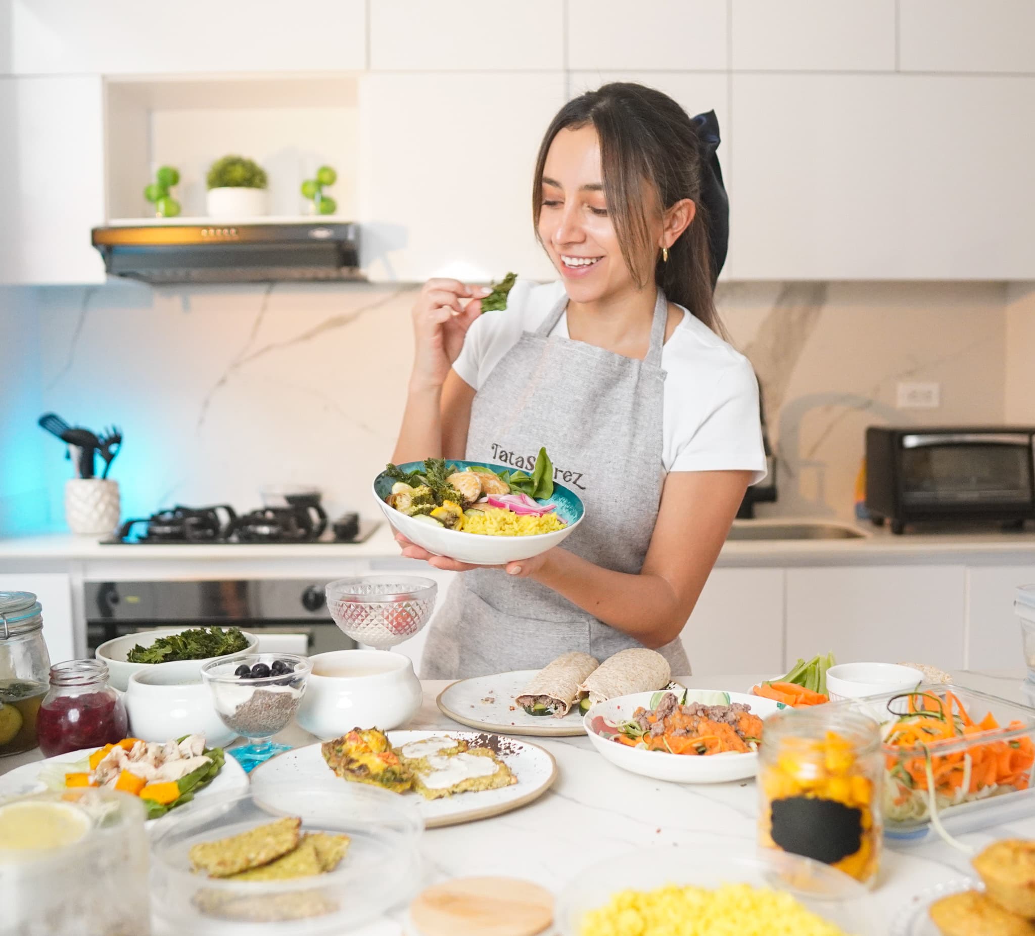 Tasting a leaf from a finished grain bowl in a bright kitchen