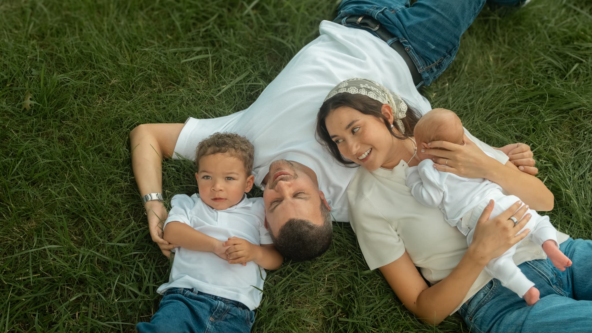 A family lying together in the grass during a portrait session